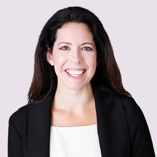 Rachel stands against a white backdrop, smiling at the camera